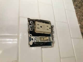 Missing cover plate and exposed wiring at a kitchen outlet documented as an inspection deficiency
