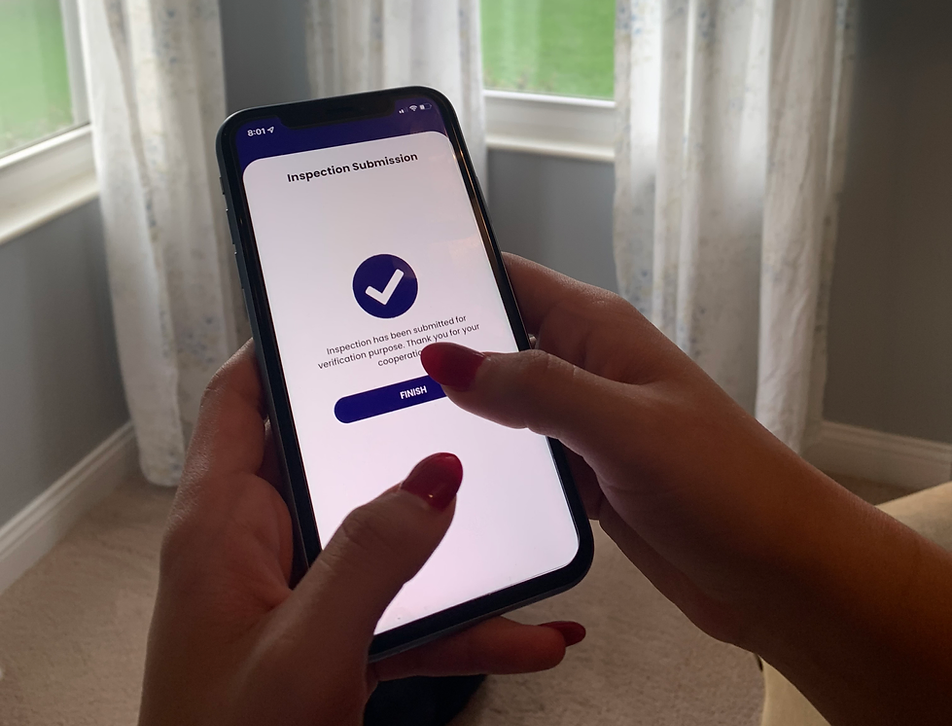 Inspector submitting a completed housing inspection through a mobile inspection app on a smartphone