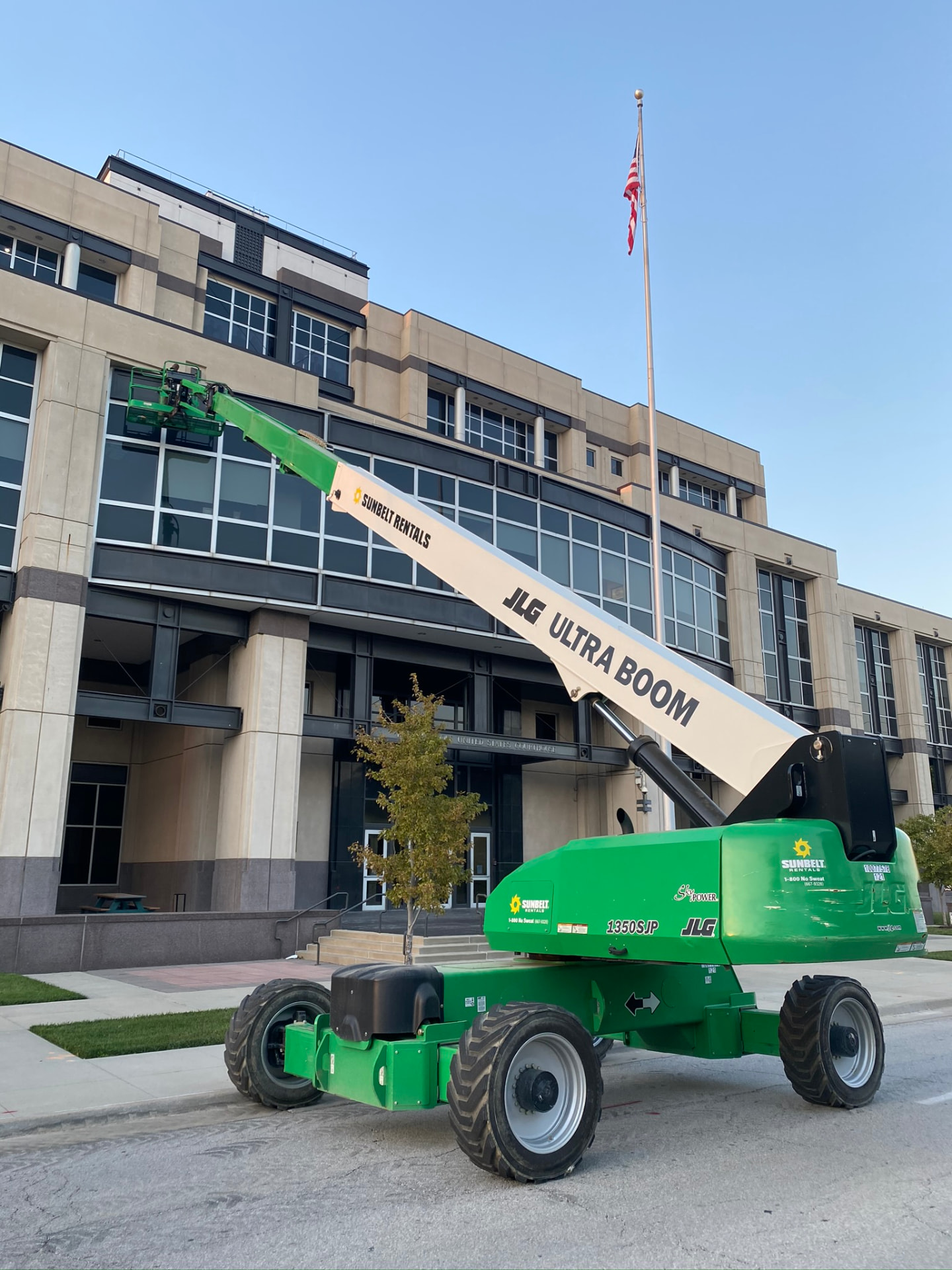 Boom lift positioned in front of a federal courthouse during exterior renovation work